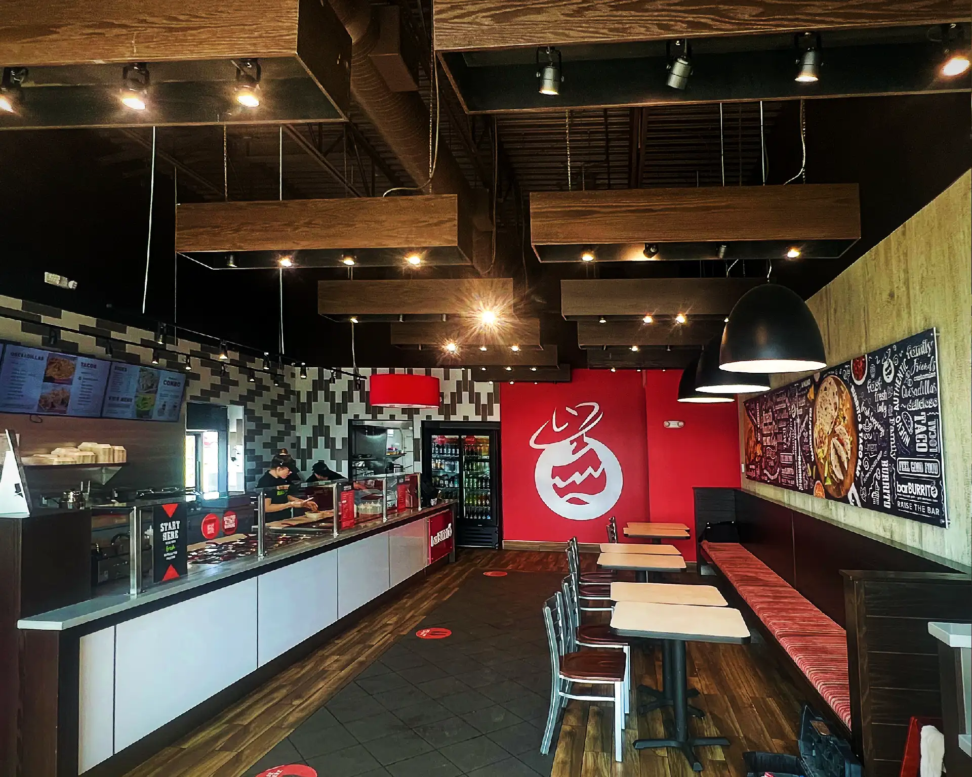 The interior of a restaurant, including a dining area with built-in seating and a full service counter.